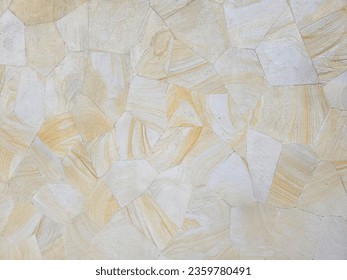 SANDSTONE FEATURE ANGLE PATTERNED BACKGROUND - Closeup of natural solid light colored streaks, grainy textured sand stone rock in a random layed pattern with straight cut edges for paved floor or wall