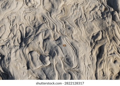 Sandstone formation shows wavy layers and ripples created by natural erosion