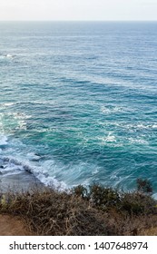 sandstone path overlooking cliff side, pacfic ocean expanse, and waves on the shore