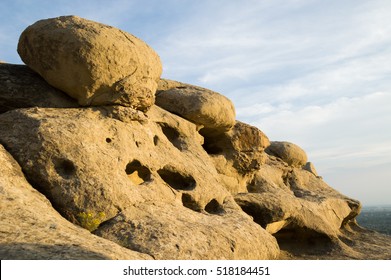 Sandstone rock formations viewed from an angle at sunset. Formations have crevices and holes from water erosion. Photographed in natural light at Zimmerman Park, Billings Montana.