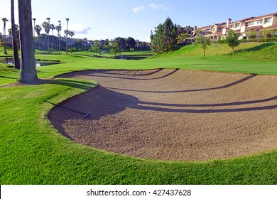Sandtrap and Manicured green grass of fairway on a golf course