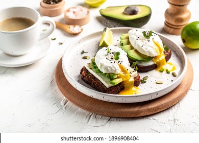 Sandwich with avocado and Poached Egg. Wholemeal Bread Toast sliced avocado and egg with cup of coffee for healthy breakfast or snack, copy space. - Powered by Shutterstock