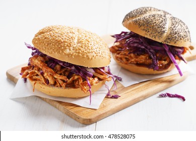 Sandwich With Barbecue Pulled Chicken And Red Cabbage On White Wooden Table