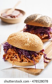 Sandwich With Barbecue Pulled Chicken And Red Cabbage On White Wooden Table