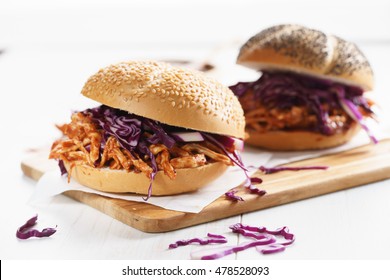 Sandwich With Barbecue Pulled Chicken And Red Cabbage On White Wooden Table