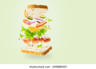 A Sandwich With Beautiful Bright Ingredients In A State Of Levitation. Light Pastel Colors. Pale Green Background. Abstraction. No People. There Is An Empty Space For Your Insert.