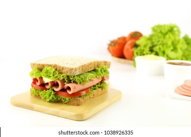 Sandwich with bologna, tomato, lettuce, cheese, tomato sauce on wooden plate white background side view