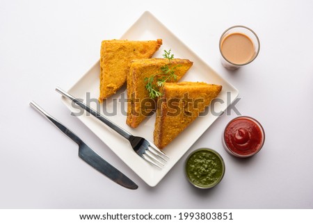 Sandwich Bread Pakora or triangle shape pakoda served with tomato ketchup, green chutney, Popular indian tea-time snack