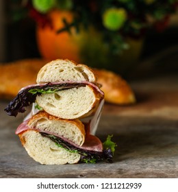 sandwich with bread rolls, lettuce, sausage ham on wooden background. Picnic food. top view