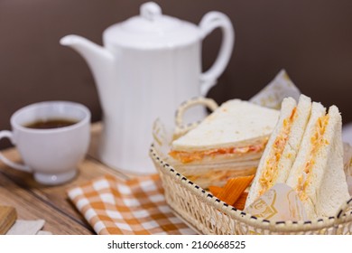 Sandwich or Bread stuffed with mix salad mayonnaise with tea or coffee pot and cup lunch break food served on table 