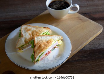 Sandwich Cheese And Thick Ham With Veg. In White Dish And Black Coffee All Put On Wooden Chopping Board / Select Focus, Space For Text

