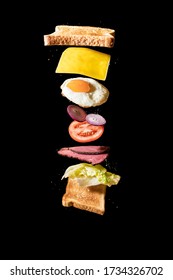 Sandwich With Flying Ingredients Isolated On Black Background.