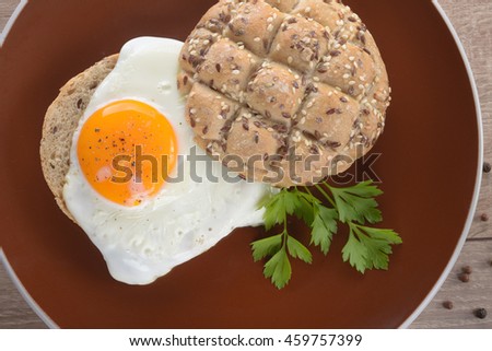 Sandwich with a fried egg on a wooden table dark.