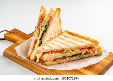 Sandwich with ham, cheese, tomatoes, lettuce, and toasted bread.