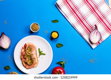 Sandwich With Ham And Mustard On A White Ceramic Plate, Blue Backgrounds With Ingredients, Top View