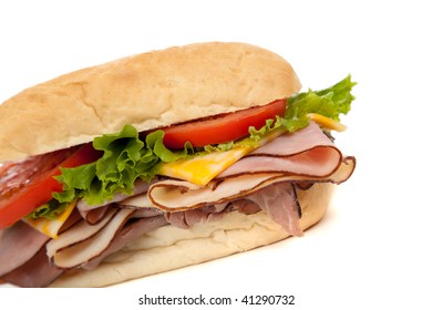 Sandwich With Ham, Turkey, Roast Beef, Lettuce, Tomato And Cheese On A White Hoagie Bun On A White Background