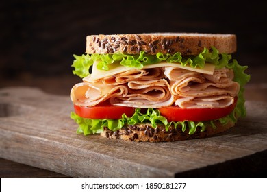 sandwich with ham and vegetables on a wooden table