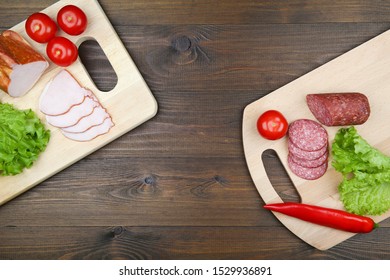 sandwich ingredients: sliced salami sausage, tomato, chili pepper, sliced ham and lettuce on two cutting boards on a dark wooden background with copy space. cutting boards with food. - Shutterstock ID 1529936891