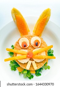 Sandwich Made And Garnished In The Shape Of Rabbit Face To Attract Children. The Sandwich Is Made Of Bred Slice, Papaya, Tomato, Banana And Coriander Leaf. It Is Placed In A White Plate.