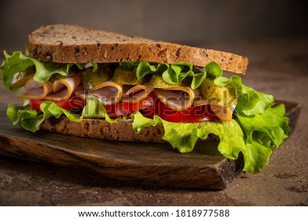Sandwich made from rustic rye bread, lettuce, tomato and ham