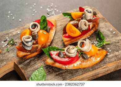 sandwich with marinated anchovies and fresh tomato, olive oil on a wooden board. banner, menu, recipe place for text, top view, - Powered by Shutterstock