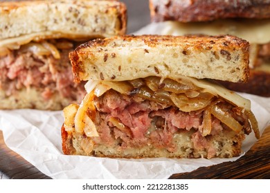 Sandwich Patty Melt Consisting Of Layer Caramelized Onions, Cheese, And Burger Patty Between Toasted Bread Closeup On The Wooden Board On The Table. Horizontal
