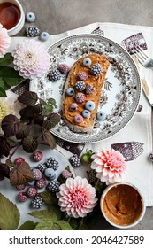 Sandwich With Peanut Butter And Frozen Berries On A Vintage Plate On The Table With Flowers And Leaves. Light Breakfast.