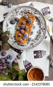 Sandwich With Peanut Butter And Frozen Berries On A Vintage Plate On The Table With Flowers And Leaves. Light Breakfast.