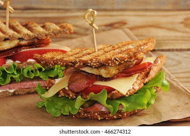 Sandwich With  Pickles On A Paper Towel On Wooden Background In Rustic Style. The View From The Top