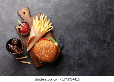Sandwich, potato fries chips and cola with ice. Fast food take away. Top view with copy space
