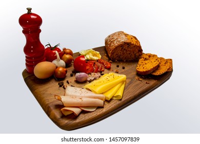 Sandwich Preparation Photo: Bread Loaf, Vegetables (tomato, Onions, Garlic), Eggs, Ham And Cheese On A Wooden Tray