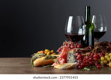 Sandwich with prosciutto, blue cheese and rosemary on a dark background. Delicious snack and red wine. Copy space. - Powered by Shutterstock