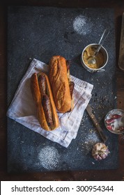 Sandwich Recipe - Bread Roll, Grilled Sausage, Green Salad Leaves, Yellow Mustard And Basil. Ingredients On Black Chalkboard From Above. Poster Layout With Free Text Space.