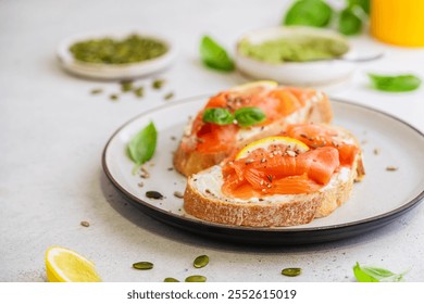 Sandwich with ricotta (cream cheese), smoked salmon and micro greens served on white background. Health care, super food concept.