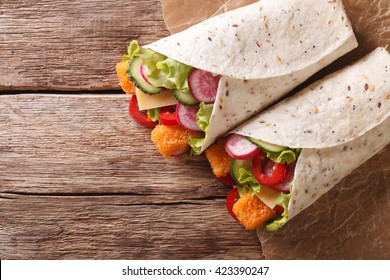 Sandwich Roll With Fish Fingers, Cheese And Vegetables Close-up On The Table. Horizontal View From Above
