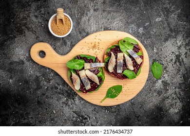 Sandwich With Slices Of Atlantic Herring Fillet, Beetroot Salad, Green Spinach, Onion, Scandinavian Cuisine. Restaurant Menu, Dieting, Cookbook Recipe, Vertical Image. Top View. Place For Text,