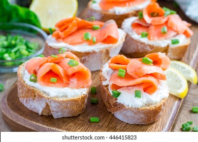 Sandwich with smoked salmon and cream cheese on wooden board, horizontal