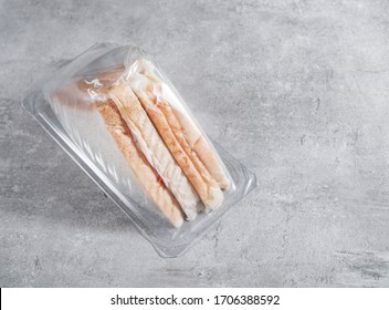 Sandwich In A Transparent Plastic Box Or Nylon Bag To Go On Gray Background