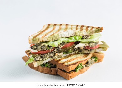 Sandwich with tuna and fresh vegetables on a white background, isolated. Close-up with a copy space for the text. Horizontal orientation. American classic food.