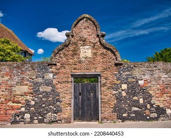 Sandwich, UK - Jun 28 2022: An Old Wooden Gate Surrounded By An Arch Of Rustic Brickwork And Stone Facing On Both Sides. A Plaque On The Left Is Inscribed The King’s Lodging - Strand Street, Sandwich.