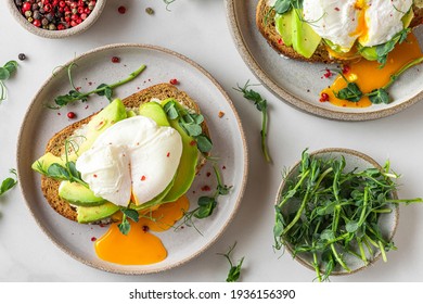 Sandwiches with avocado, poached egg, sprouts and cheese for healthy breakfast on white background. top view. Healthy diet food