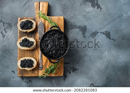 Sandwiches with black caviar and butter, on gray background, top view flat lay  with copy space for text