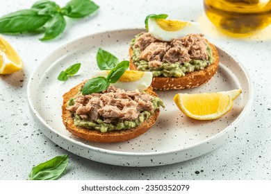 sandwiches with canned tuna, boiled egg and avocado. Food recipe background. Close up.