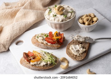 Sandwiches With Cashew Cream Cheese On A Cutting Board, Bowl With Fermented Vegan Nut Cheese On A White Background, Healthy Food Concept.