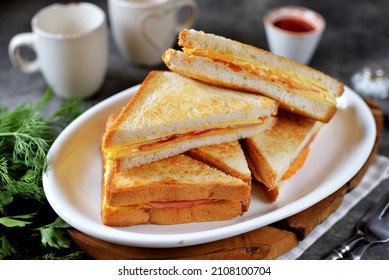 Sandwiches with egg, ham and toast cheese fried in a pan.
