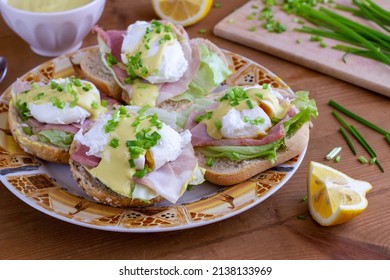 Sandwiches With Poached Egg, Ham, Lettuce, And Chives, Topped With Sauce. Eggs Benedict