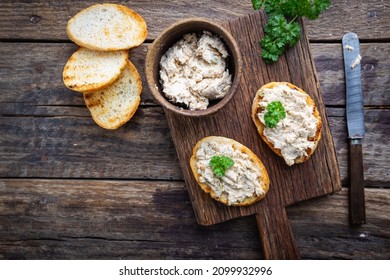 Sandwiches with salmon pate and baguette, fish bruschetta, top view. Rustic homemade Italian cuisine.