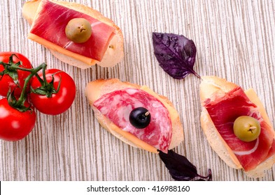 Sandwiches with sausage and jamon. On a light background. - Shutterstock ID 416988160