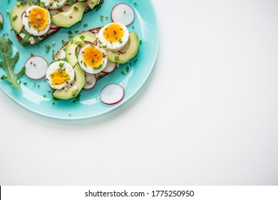 Sandwiches With Soft Boiled Egg, Avocado, Radish, Arugula, Green Onion And Flax Seeds On Blue Plate. Healthy Snack.