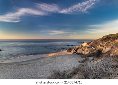 Sandy Beach Above Malibu, California In Early Morning. Calm Pacific Ocean In The Distance; Blue Sky And Clouds Overhead.
